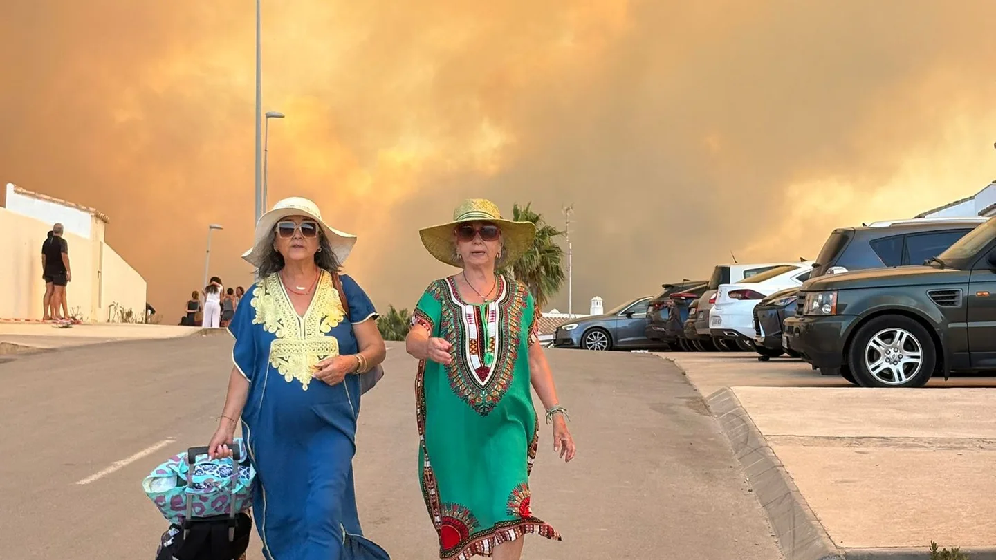 Dos mujeres durante el desalojo preventivo de viviendas, hoteles y la playa de los Alemanes por el fuego en Tarfia este lunes. Dos mujeres durante el desalojo preventivo de viviendas, hoteles y la playa de los Alemanes por el fuego en Tarfia este lunes.