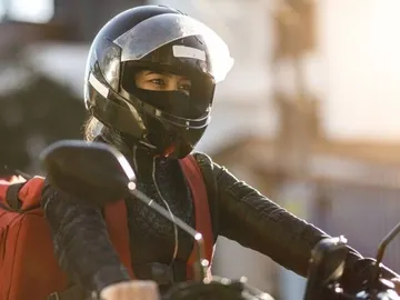 Conductora de una motocicleta con una máscara Conductora de una motocicleta con una máscara