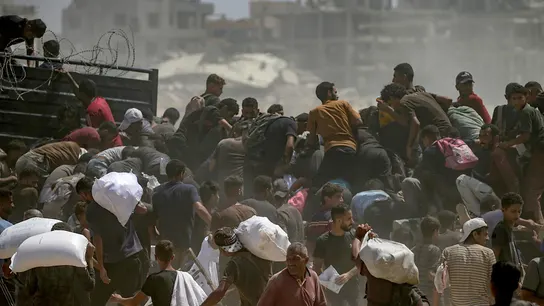 Palestinos desplazados internamente intentan conseguir bolsas de harina de un camión de ayuda Palestinos desplazados internamente intentan conseguir bolsas de harina de un camión de ayuda