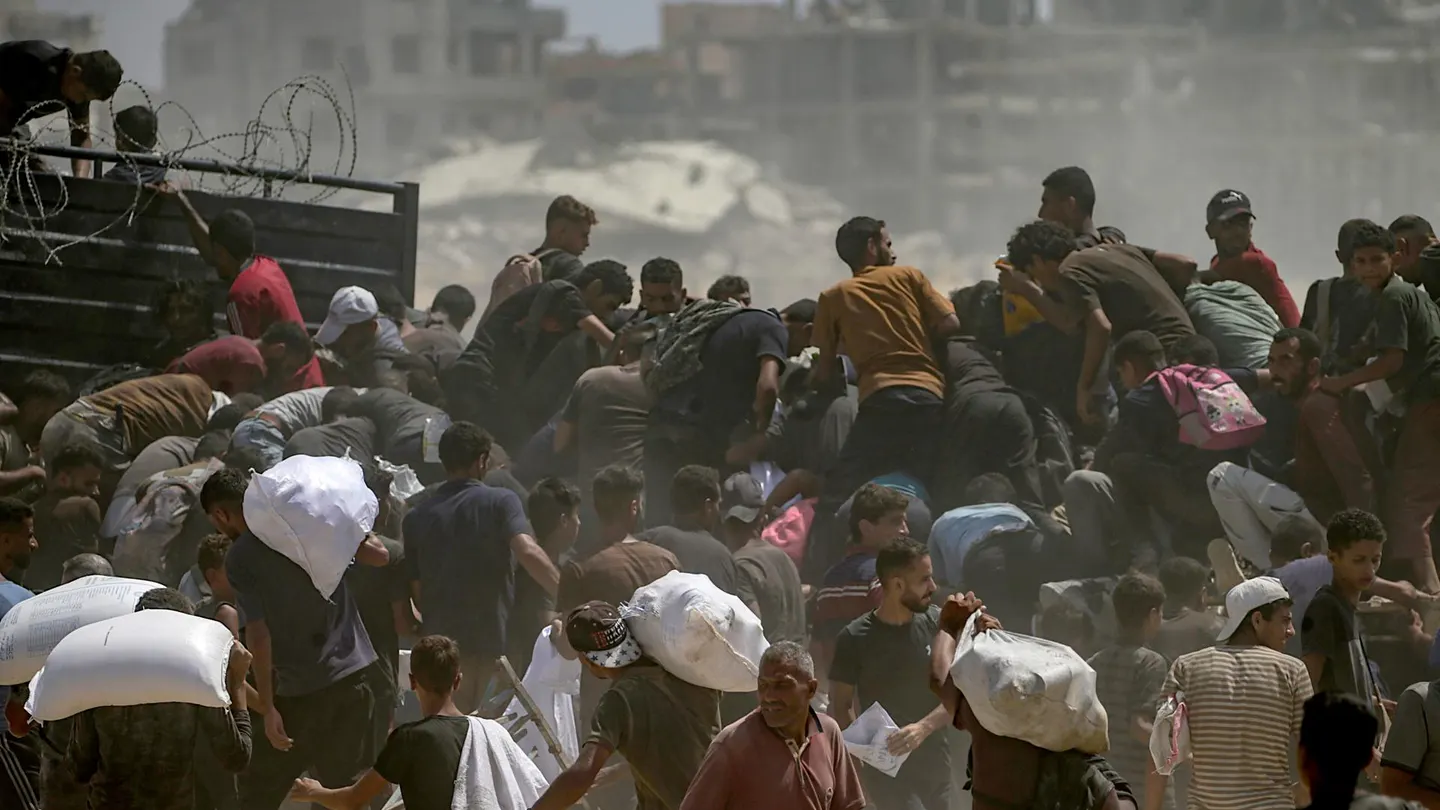 Palestinos desplazados internamente intentan conseguir bolsas de harina de un camión de ayuda Palestinos desplazados internamente intentan conseguir bolsas de harina de un camión de ayuda