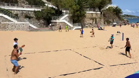 Cuatro personas juegan a las palas en la playa Cuatro personas juegan a las palas en la playa