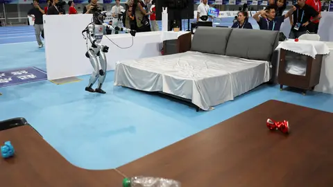 Robot participando en una prueba de limpiar una habitación Robot participando en una prueba de limpiar una habitación
