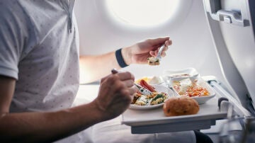 Pasajero comiendo en el avión