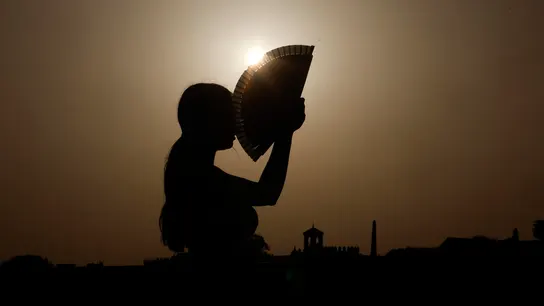 Una persona se abanica por el calor Una persona se abanica por el calor