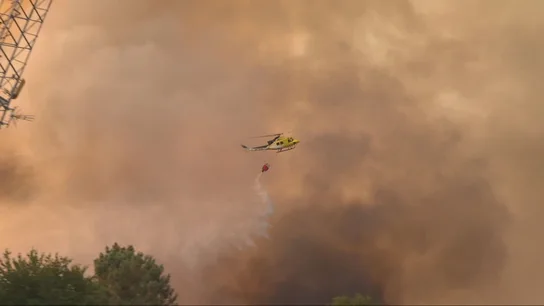 Un helicóptero echa agua sobre un incendio Un helicóptero echa agua sobre un incendio