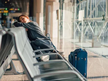 Chica pasando el jet lag en el aeropuerto Chica pasando el jet lag en el aeropuerto