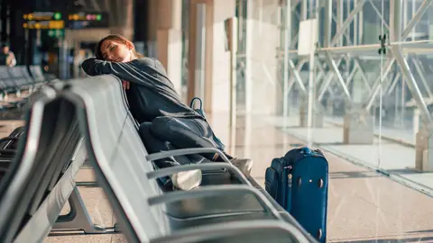 Chica pasando el jet lag en el aeropuerto Chica pasando el jet lag en el aeropuerto