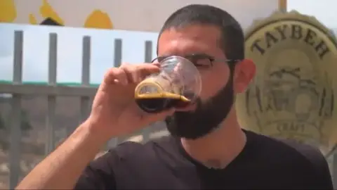 Un hombre bebiendo Taybeh Un hombre bebiendo Taybeh
