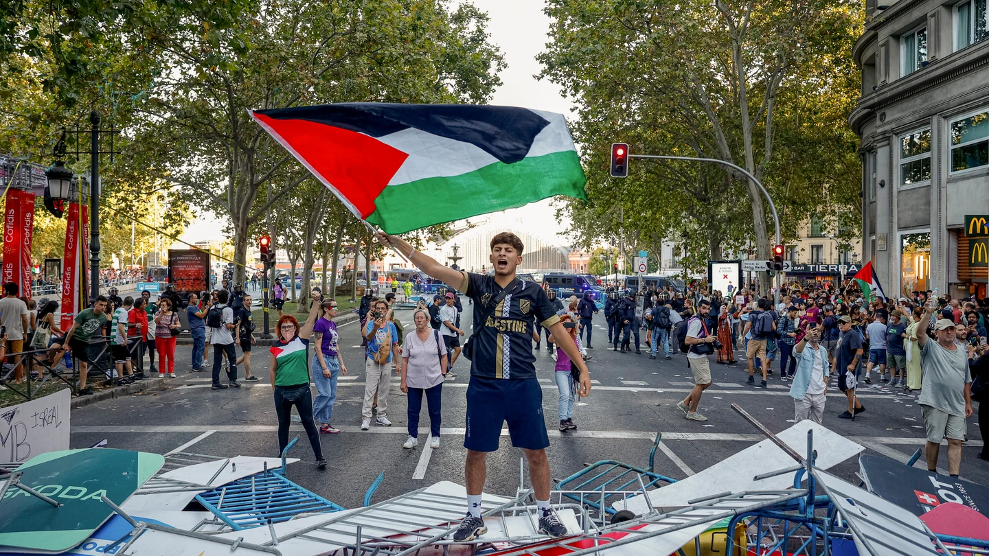 Un manifestante ondea la bandera de Palestina durante las protestas en la etapa final de La Vuelta Un manifestante ondea la bandera de Palestina durante las protestas en la etapa final de La Vuelta