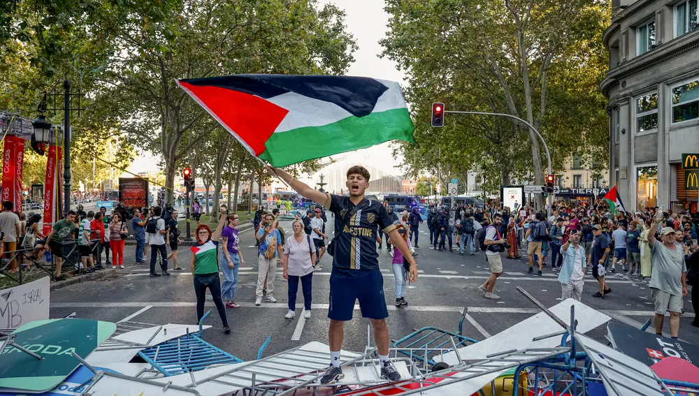Un manifestante ondea la bandera de Palestina durante las protestas en la etapa final de La Vuelta Un manifestante ondea la bandera de Palestina durante las protestas en la etapa final de La Vuelta