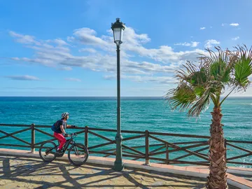 Mujer en bicicleta en la playa Mujer en bicicleta en la playa