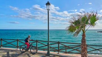 Mujer en bicicleta en la playa