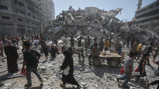Ciudadanos palestinos caminan por los restos de una Franja de Gaza destruida por los ataques israelíes Ciudadanos palestinos caminan por los restos de una Franja de Gaza destruida por los ataques israelíes