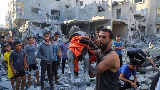 Un hombre lleva el cuerpo de una niña palestina asesinada. Un hombre lleva el cuerpo de una niña palestina asesinada.