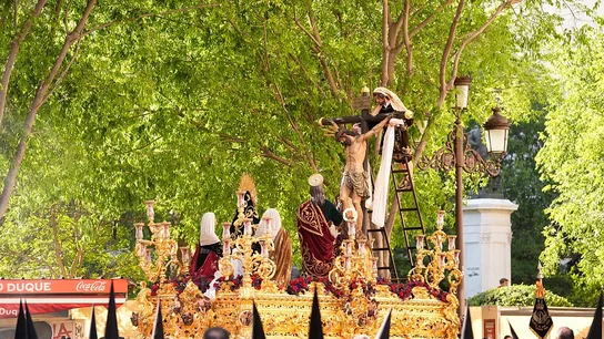 Una de las procesiones de la Semana Santa de Sevilla. Imagen de una de las procesiones de la Semana Santa de Sevilla con el paso, cofrades y espectadores.