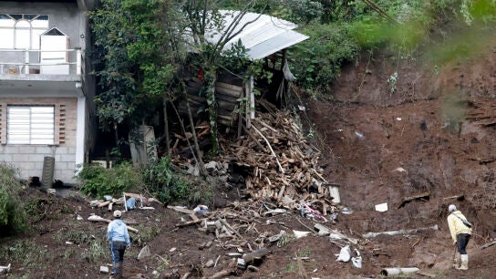 Personas observan una zona afectada por las fuertes lluvias este domingo, en Huauchinango (M&eacute;xico)
