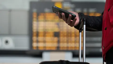 Chico con el teléfono móvil en el aeropuerto Chico con el teléfono móvil en el aeropuerto