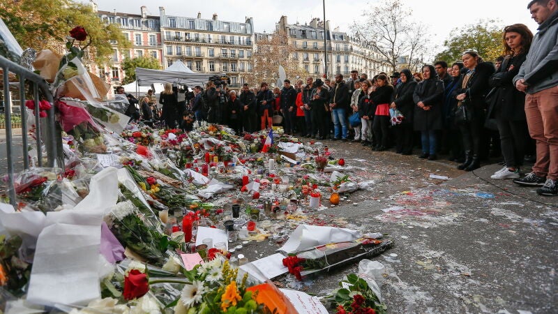 Miles de personas guardan un minuto de silencio cerca de la sala de conciertos Bataclan en París, Francia.