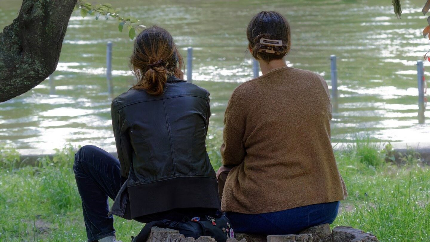 Dos mujeres miran un lago