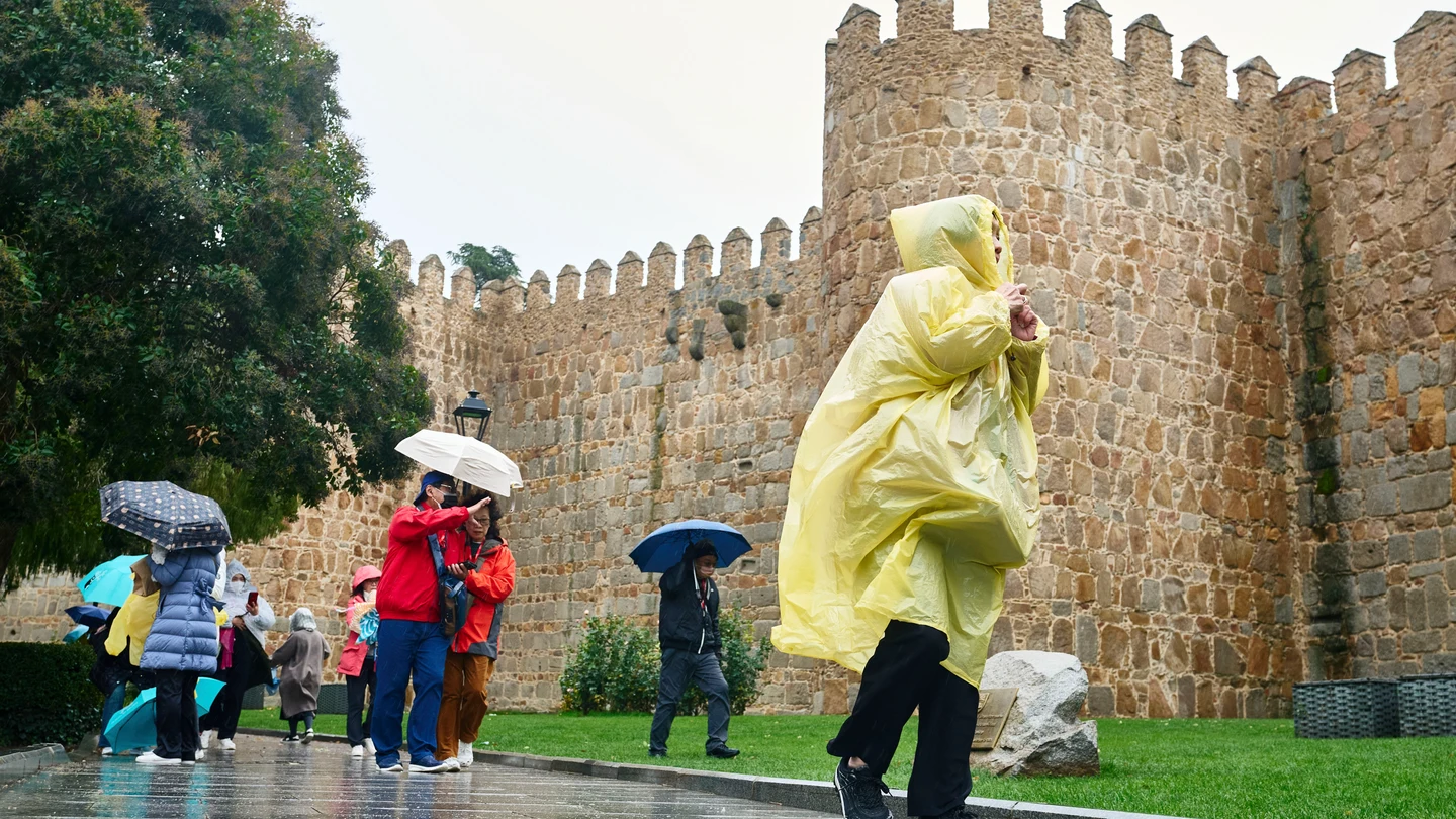 Varias personas se protegen de la lluvia en Ávila Varias personas se protegen de la lluvia en Ávila