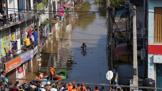 Un hombre camina por una calle inundada tras las fuertes lluvias en Wellampitiya, Sri Lanka.