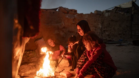 Una mujer palestina desplazada internamente cocina sobre una fogata en un campamento informal en Khan Younis Una mujer palestina desplazada internamente cocina sobre una fogata en un campamento informal en Khan Younis