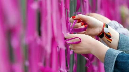 Un grupo de mujeres coloca lazos morados durante un acto feminista Un grupo de mujeres coloca lazos morados durante un acto feminista