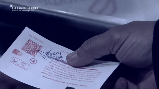 Una persona comparte su décimo con su firma por detrás. Una persona comparte su décimo con su firma por detrás.