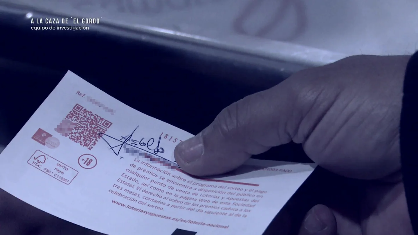 Una persona comparte su décimo con su firma por detrás. Una persona comparte su décimo con su firma por detrás.