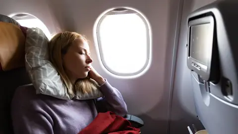 Chica joven durmiendo en el avión Chica joven durmiendo en el avión