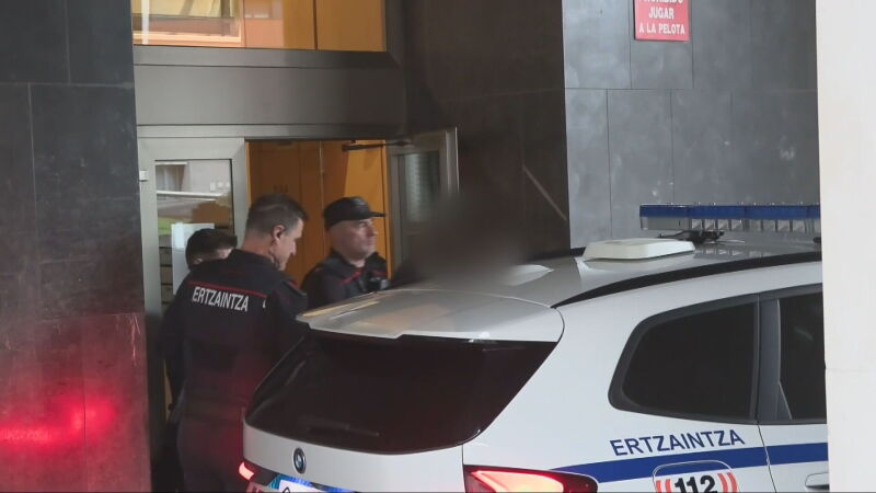 Imagen en la que agentes de la Ertzaintza sacan al principal acusado del domicilio de la mujer asesinada