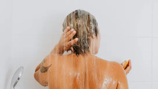 Mujer de espaldas en la ducha Mujer de espaldas en la ducha