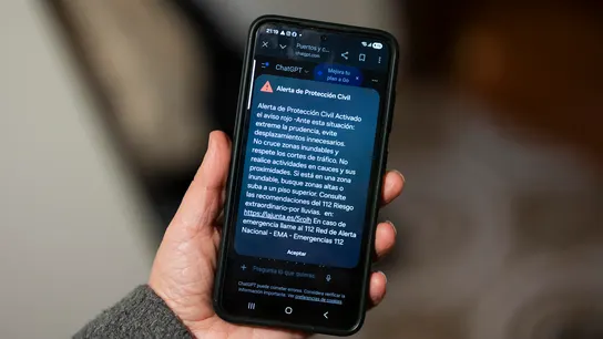 Una persona sostiene un teléfono móvil con la alerta enviada por protección civil de aviso rojo. Una persona sostiene un teléfono móvil con la alerta enviada por protección civil de aviso rojo.