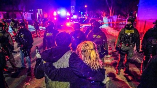 Dos personas, frente al ICE en Minneapolis