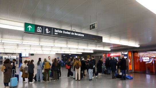 Los viajeros aguardan en el vest&iacute;bulo de la estaci&oacute;n Puerta de Atocha en Madrid, con los accesos direcci&oacute;n Sevilla y M&aacute;laga cerrados.