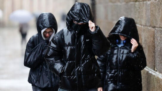 Varias personas se protegen de la lluvia en Galicia