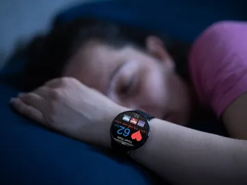 Mujer durmiendo con reloj inteligente Mujer durmiendo con reloj inteligente