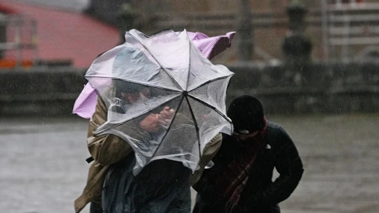 Varias personas intentan sujetar sus paraguas en Santiago de Compostela, A Coruña, Galicia (España). Varias personas intentan sujetar sus paraguas en Santiago de Compostela, A Coruña, Galicia (España).