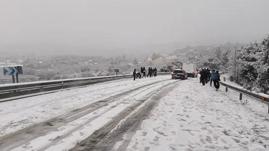 Varias personas durante la nevada en la carretera M-519 a la altura de Galapagar Varias personas durante la nevada en la carretera M-519 a la altura de Galapagar