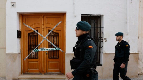 Miembros de la Guardia Civil pasan delante del portal de la vivienda de Sueca (Valencia) donde fue asesinado un ni&ntilde;o de 13 a&ntilde;os