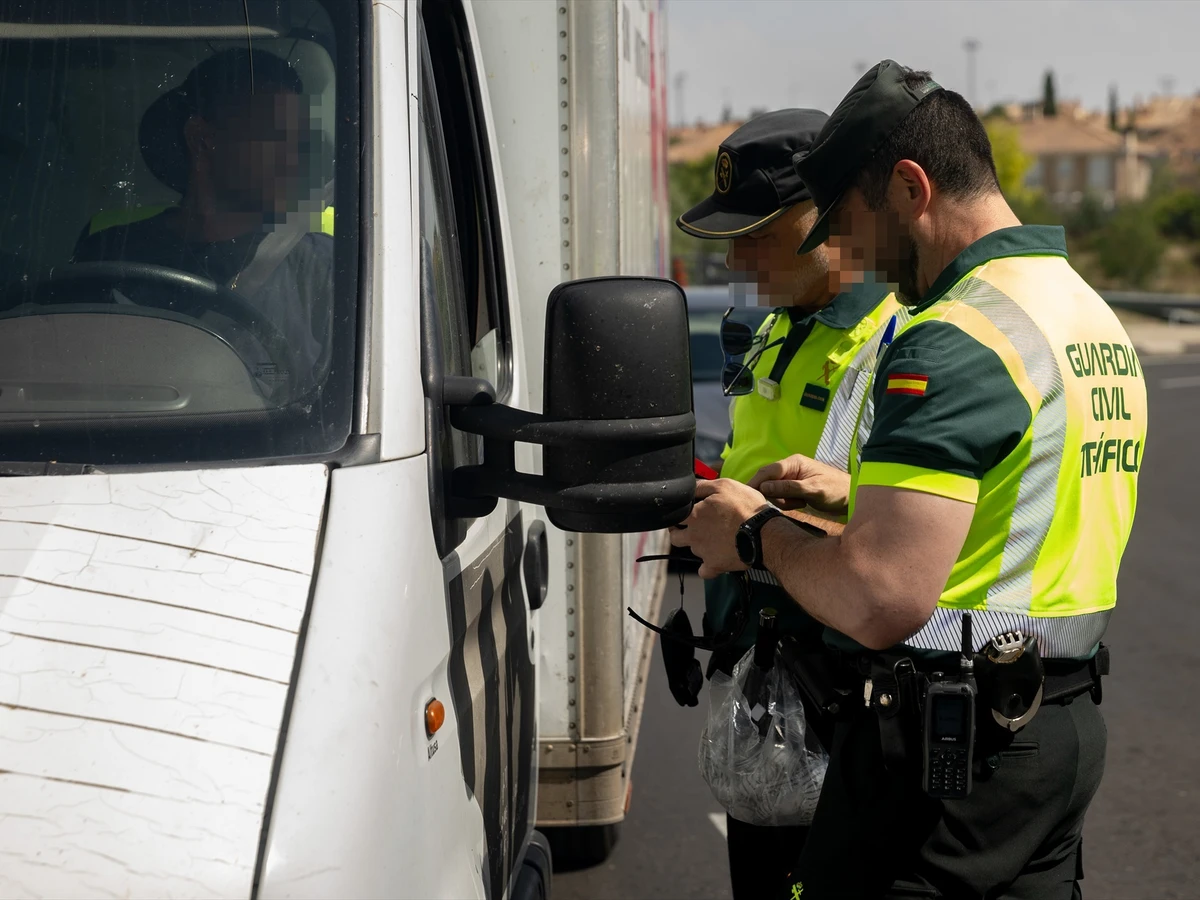 Agentes de la Guardia Civil de Tráfico realizan un control a un vehículo pesado