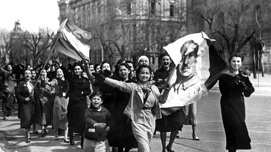 Un grupo de muchachas recorren alegres las calles de Madrid, con un retrato de Franco y la bandera nacional. Un grupo de muchachas recorren alegres las calles de Madrid, con un retrato de Franco y la bandera nacional.