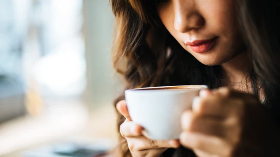 Una mujer tomando una taza de café. Una mujer tomando una taza de café.