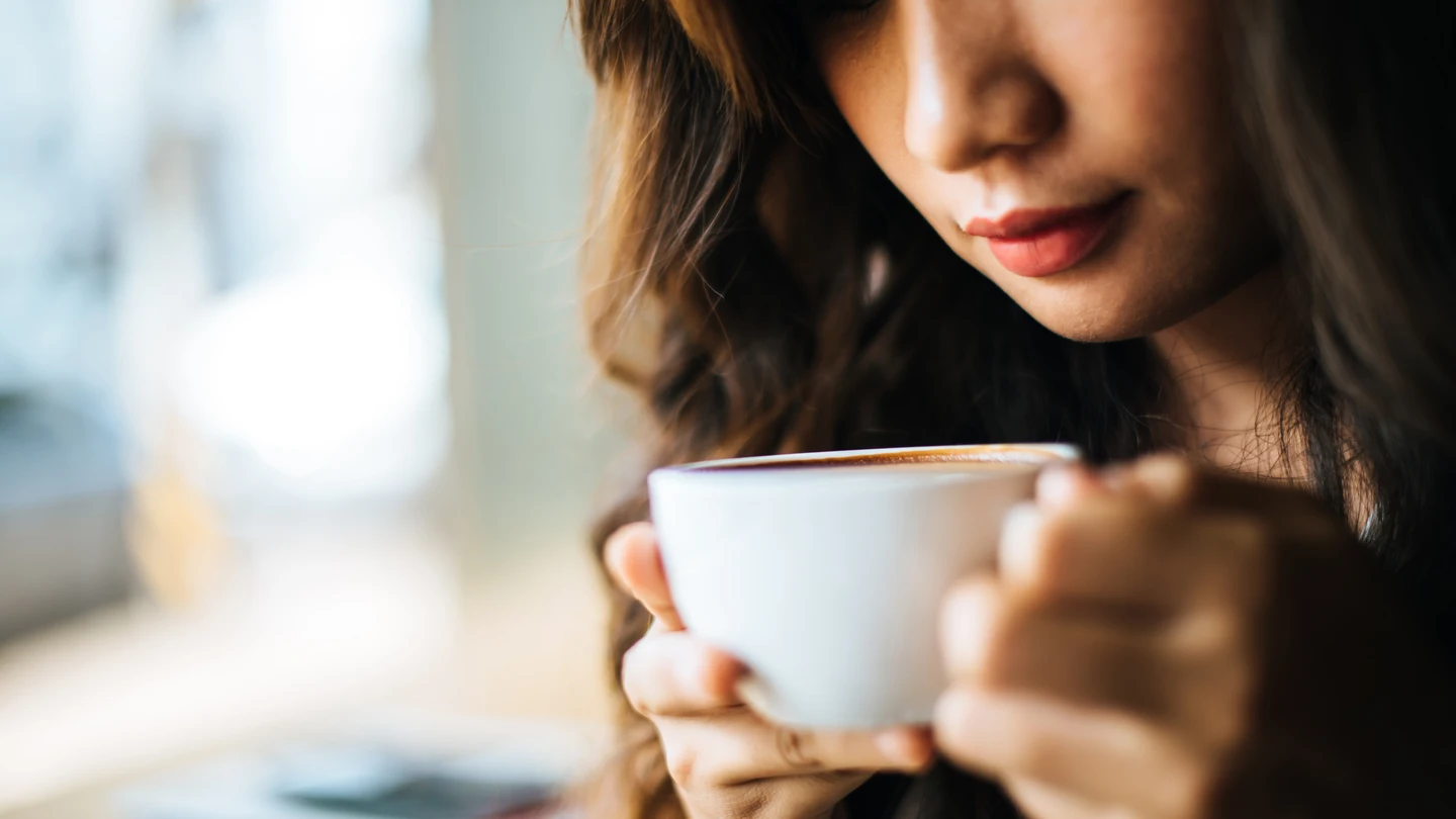 Una mujer tomando una taza de café. Una mujer tomando una taza de café.