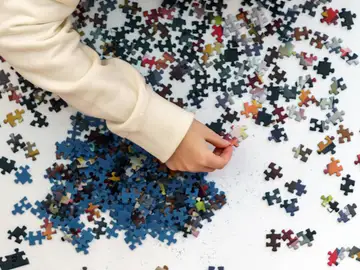 Una persona resolviendo un rompecabezas Una persona resolviendo un rompecabezas