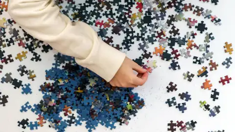 Una persona resolviendo un rompecabezas Una persona resolviendo un rompecabezas