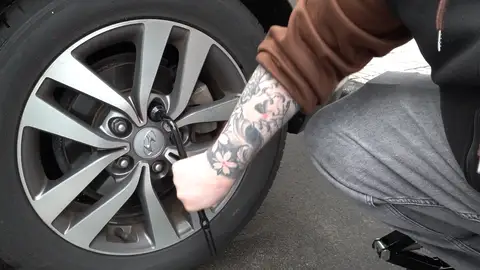 Hombre cambiando una rueda Hombre cambiando una rueda