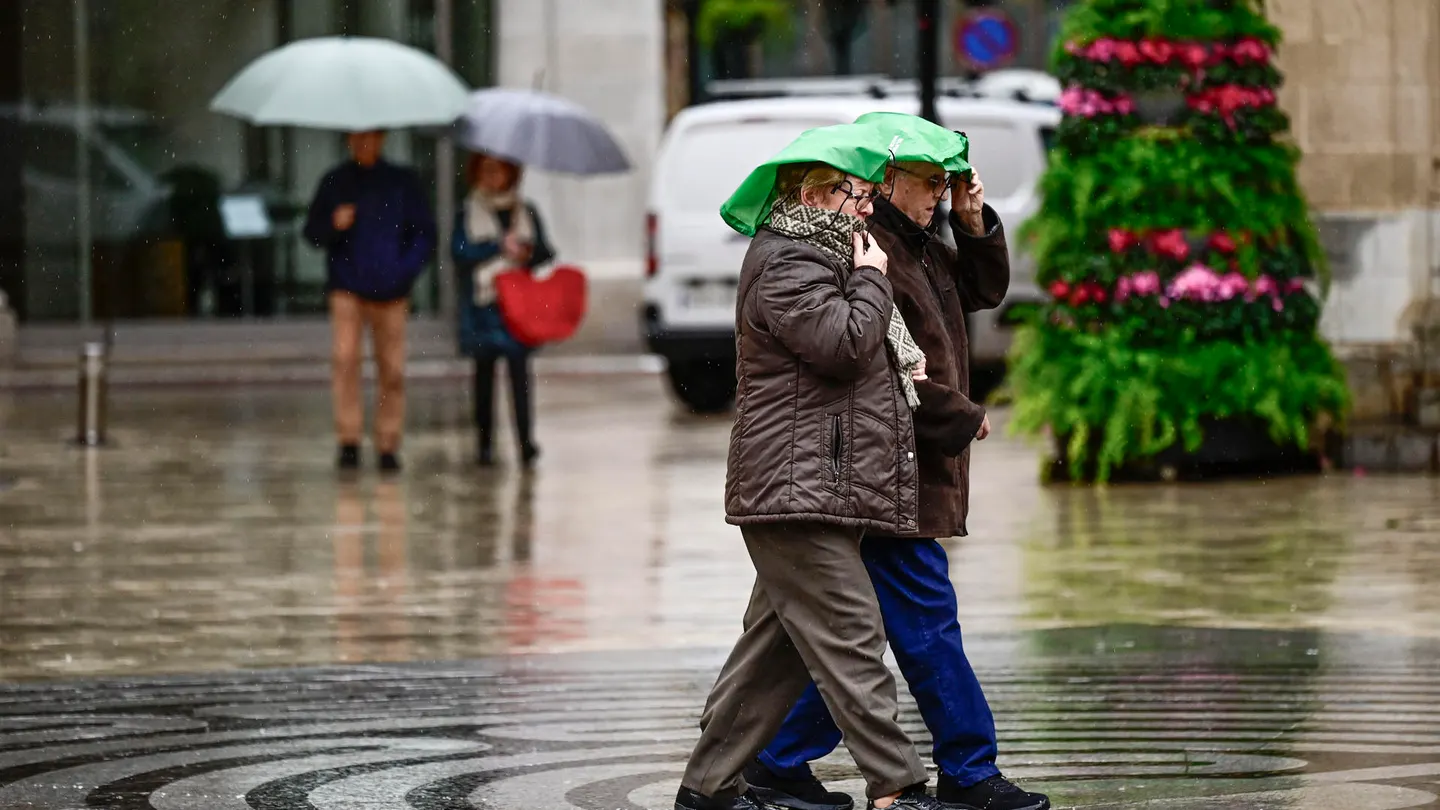 En la imagen varias personas caminan bajo la lluvia por las calles del centro de Castellón. En la imagen varias personas caminan bajo la lluvia por las calles del centro de Castellón.