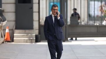 El ministro de la Presidencia, Relaciones con las Cortes y Memoria Democr&aacute;tica, F&eacute;lix Bola&ntilde;os, habla por tel&eacute;fono en las inmediaciones del Congreso de los Diputados