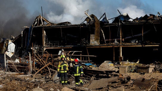 Bomberos inspeccionan la zona frente a una instalaci&oacute;n industrial da&ntilde;ada durante un ataque con misiles y drones rusos
